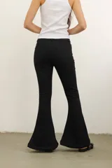 Pantalón de jean negro con corte ajustado en la cadera y muslos, y acampanado extremo desde la rodilla.