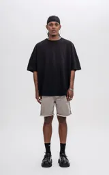 Remera negra de manga corta con calce extra oversize y recorte horizontal en el delantero y la espalda.