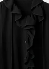 Blusa negra de viscosa con cuello redondo, detalle de fular anudado al cuello y volantes. Presenta mangas largas con puños abotonados y cierre frontal con botones.