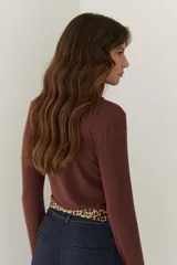 Remera color beige de mangas largas con cuello redondo y puños blancos en contraste.