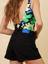 Short de jean blanco de cintura alta, corte slim fit, con cierre de botón y cremallera.