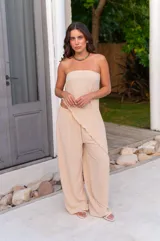 Pantalón de corte amplio y tiro medio, confeccionado en tela crepe color beige, con diseño fluido y holgado.