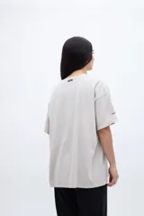 Remera gris con efecto marmolado, calce boxy, diseño fotográfico y texto en el frente.