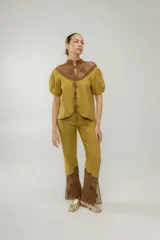 Pantalón de lino color ocre, de tiro medio y pierna recta. Cuenta con detalle de crochet tejido a mano en la pierna baja.