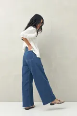 Pantalón jean ancho de tiro alto color azul oscuro, con bolsillos delanteros amplios y corte palazzo.