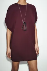 Vestido corto de tejido de punto elástico, color bordó, con cuello redondo, manga caída y cierre posterior con cremallera.