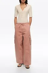 Pantalón cargo de corte wide leg, color rosado lavado, con bolsillos laterales con solapa y cintura elastizada ajustable con cordón.