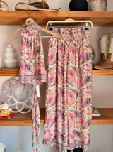 Conjunto de dos piezas color fucsia con estampado oriental en tonos rosa y blanco, compuesto por un top halter con lazo en la cintura y un pantalón palazzo de cintura alta con elástico.