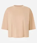 Remera cropped de manga corta, cuello redondo y calce oversized, confeccionada en tejido de algodón tipo media malla.