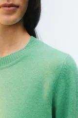 Sweater de tejido de punto verde, con calce regular levemente suelto, escote redondo y mangas largas con puños acanalados.