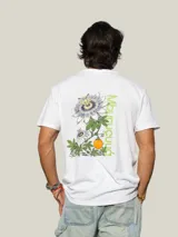 Remera de algodón blanca con cuello redondo y manga corta, presenta un pequeño estampado de un fruto de mburucuyá en el lado izquierdo del pecho.