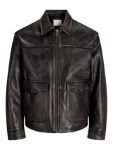 Campera de cuero marrón con cuello biker y cierre con cremallera. Confeccionada en cuero de cabra suave, naturalmente resistente al agua. Presenta mangas largas y bolsillos frontales con cierre de botón.