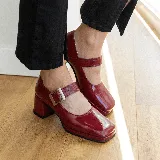 Zapato estilo Mary Jane de cuero vacuno con acabado brillante, punta cuadrada y taco bloque. Cuenta con una tira ajustable sobre el empeine con hebilla metálica.