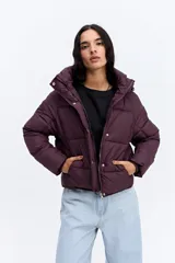 Campera puffer negra con capucha, diseño corto y acolchado, cierre frontal con botones a presión y puños ajustados.