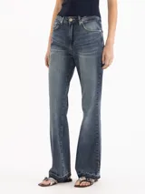 Jeans Fred de tiro alto y corte recto, con diseño ligeramente acampanado hacia el dobladillo, lavado azul medio con efecto desgastado y detalles deshilachados en los tobillos.