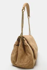 Bolso de hombro de piel color tostado con diseño acolchado y costuras geométricas. Cuenta con tres compartimentos, uno de ellos con cierre de cremallera, y solapa con cierre magnético. Incluye asa combinada de piel y cadena metálica dorada.