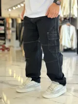 Pantalón cargo de jean azul con múltiples bolsillos en los laterales y diseño holgado.