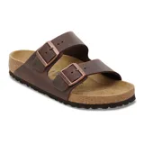 Sandalia Birkenstock modelo Arizona de dos correas ajustables con hebillas metálicas. Presenta una capellada de cuero engrasado color marrón y una plantilla anatómica de corcho con suela de goma.