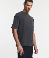 Remera de corte boxy y diseño liso, confeccionada en algodón con efecto desteñido, cuello redondo alto y mangas cortas.