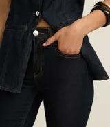 Pantalón bootcut de jeans raw con cintura alta, bolsillos delanteros y traseros, cierre con botón y cremallera.