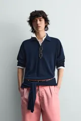 Jersey de punto color azul marino, de corte relajado, con cuello solapa y cierre frontal de tres botones. Presenta mangas largas y acabados en rib en puños y bajo.