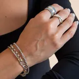 Anillo de diseño ancho confeccionado en plata 925 y oro, con textura estriada y acabado bicolor.