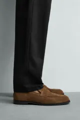 Mocasín casual fabricado en piel con acabado de serraje, con detalle de bordón y antifaz en el empeine, horma redonda y suela a contraste.