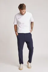 Pantalón de vestir azul marino, de corte recto, con bolsillos laterales y traseros. Se ajusta a la cintura con cinturón de cuero marrón.