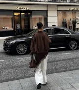 Chaqueta tipo bomber de color marrón, confeccionada en gamuza, con cuello camisero, mangas amplias y corte holgado a la cintura.