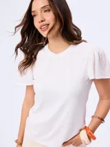 Remera blanca con cuello redondo y mangas cortas abullonadas con detalle de bordado suizo.