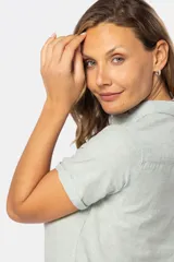 Camisa de lino de manga corta con cuello camisero, cierre frontal de medio botón con botones metálicos personalizados y dos bolsillos en el pecho.
