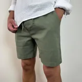 Bermuda de corte recto en color beige, confeccionada en tejido simil lino. Presenta cintura elástica con cordón de ajuste y bolsillos laterales.