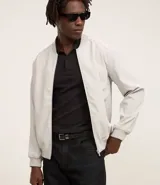 Campera bomber color gris claro, con cuello mao, cierre frontal con cremallera, bolsillos laterales y puños elásticos. Confeccionada en poliéster con tecnología repelente al agua.