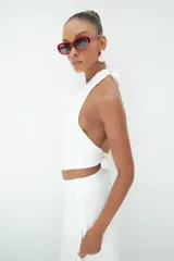 Top blanco de cuello halter con escote drapeado y espalda descubierta, confeccionado en tela de alta calidad con caída fluida.