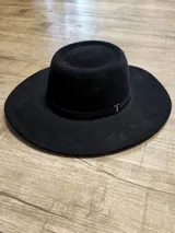 Sombrero negro de ala ancha con cinta decorativa.