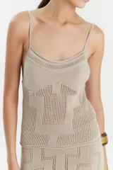 Top tejido color beige, de breteles finos y corte ajustado.