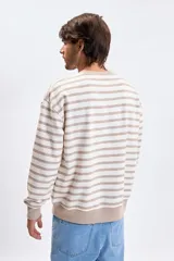 Buzo de cuello redondo con diseño de rayas horizontales en tonos crudo y beige, de corte holgado y mangas largas con puños elásticos.