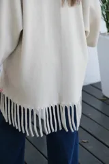 Saco abierto de corte recto y holgado, color visón, con mangas tres cuartos y detalle de flecos largos en el ruedo.