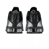 Championes Nike Shox R4 de diseño técnico en color negro total. Presentan la icónica tecnología de amortiguación Shox en el talón, con una estructura de columnas que proporciona soporte y respuesta. El exterior combina cuero sintético con paneles perforados para mayor ventilación y un acabado elegante.
