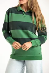 Sweater de punto con diseño de rayas horizontales anchas en tonos verde oscuro y verde claro, con cuello tipo polo y cierre frontal parcial. Presenta mangas largas con puños elásticos y un pequeño bordado en la parte inferior.