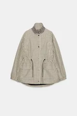 Chaqueta de corte holgado con estampado de cuadros, cuello subido, manga larga con puños elásticos y cintura ajustable mediante cordones. Presenta bolsillos delanteros con solapa y cierre frontal con cremallera oculta y botones a presión.
