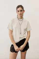 Remera lisa de color beige, con mangas cortas y cuello redondo, de corte clásico y confección en algodón.