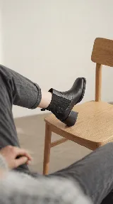 Bota tipo chelsea de cuero negro con paneles elásticos laterales y taco cuadrado de madera de 6 cm.