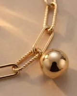 Pulsera de plata con baño de oro, compuesta por una cadena de eslabones rectangulares combinados con una cadena fina, y un dije colgante en forma de esfera lisa.