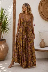 Vestido largo amplio y liviano de estilo boho, con estampado estilo paisley en tonos mostaza y violeta, escote en V profundo con cordones ajustables terminados en borlas y tirantes finos ajustables con detalles de flecos.