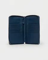 Funda porta pasaporte Prüne de cuero sintético negro con cierre de cremallera y logo grabado en la parte inferior.