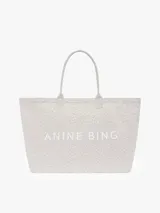 Bolso tote de lona de algodón con estampado animal print en tonos grises y blancos, doble asa superior y branding de la marca ANINE BING estampado en contraste en el frente.