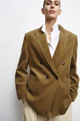 Blazer oversize de pana con cuello solapa y manga larga. Presenta cierre frontal cruzado con botones, bolsillos delanteros y forro interior a tono.