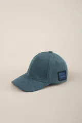 Gorra de pana color petróleo con visera curva y logo de la marca bordado en el lateral.