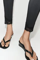 Leggings de tiro alto confeccionados en tejido de poliamida, con diseño ajustado y detalle de aplicación de encaje a tono en los tobillos.